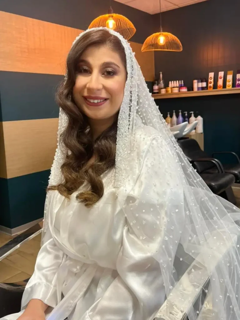 Une personne en robe de mariée se prépare dans un salon de coiffure.